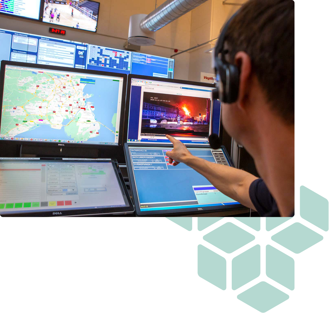operator sits in front of screens and points at live video from incidentshare